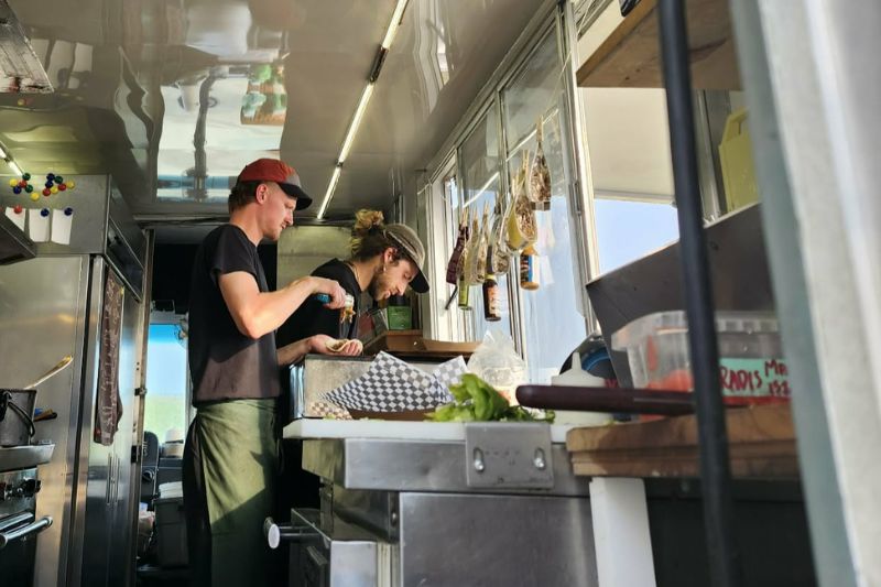 Cuisiniers à l'intérieur du foodtruck cachalot aux Îles de la Madeleine